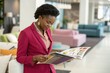 © SerPak - A woman dressed in a pink suit examines a design magazine while standing in a furniture store.
