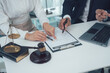 © Kritdanai - Legal Counsel: Two lawyers, one male and one female, collaborate on a case, meticulously reviewing documents and discussing strategies. The image evokes a sense of trust, expertise.