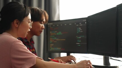 Slow motion back end software developer engineer for computer programming working together on debugging writing computing code, solving complex algorithms display on monitor in office. Burgeoning