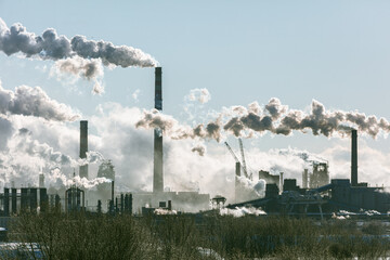 Wall Mural - A large industrial area with smoke and steam coming out of the factories