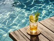 © Sopear - A refreshing cocktail sits on a rustic wooden table next to a beautiful swimming pool