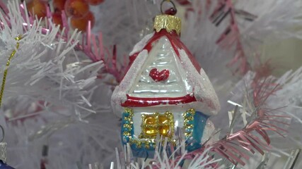 Wall Mural - Christmas Tree Toy In The Form Of A House, New Year's decorations on a white Christmas tree at Christmas time, the tradition of decorating the Christmas tree