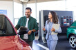 © Graphicroyalty - Young woman consultant in show room talking with client, Professional salesperson selling cars at dealership to buyer