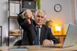 © Andrii Iemelianenko - Dislike. Upset old senior businessman working on laptop at home office thumbs down sign gesture expressing discontent, disapproval, dissatisfied bad work. Displeased serious freelancer grandpa in suit