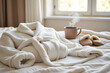 © ANASTASIIA - Cozy morning scene with fluffy bathrobe, warm slippers, and hot cup of coffee on bed