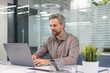 © ty - Handsome successful businessman working in office