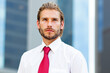 © Minerva Studio - Portrait of confident businessman wearing red tie in front of office building