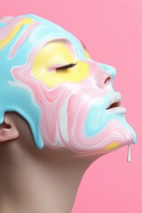 Wall Mural - A woman with a face painted in blue, pink and yellow. The colors are very bright and the woman's face is dripping paint. The painting is very colorful and vibrant, giving off a fun and playful mood