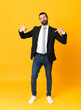 © luismolinero - Full-length shot of business man over isolated yellow background proud and self-satisfied