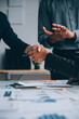 © ARMMY PICCA - Handshake in agreement against young business people in board room meeting