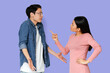 © Prostock-studio - You are lying. Asian angry girl scolding her surprised boyfriend, grey studio background