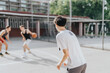 © qunica.com - A group of friends playing basketball on an old neighborhood court. They are enjoying the sunny day, displaying teamwork, and engaging in energetic competition and fun.