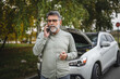 © Miljan Živković - worried man stand in front open hood of car make a phone call for help