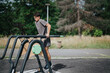 © qunica.com - Man working out on outdoor gym equipment in a park setting, enjoying a sunny day while staying fit and healthy in nature