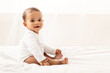 © Prostock-studio - Toddler's Portrait. Beautiful African Baby Boy Sitting In Bed Smiling To Camera Posing In Bedroom At Home, Wearing White Clothes. Happy Little Infant, Child Care Concept.