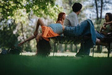 Poster - Group of young adults enjoying a sunny day in the park, relaxing and socializing on a bench amidst lush greenery.