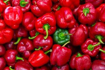 Many of red bell pepper on the counter in the grocery store. Close-up image