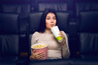 © Prostock-studio - Motion picture fun. Cute Asian girl with popcorn and drink in cinema