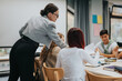 © qunica.com - A teacher engages with a group of students during a classroom activity, fostering a collaborative learning environment. The setting highlights education, teamwork, and a focus on student engagement.