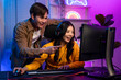 © Pavitra - Asian Esport couple gamer playing online video game on computer.