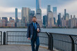 © Volodymyr - Business man drink coffee outdoor. Business man walk in business district at Manhattan. Business man in a suit standing in front of a office building in New York City. Outdoor portrait of Hispanic