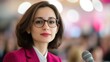 © red_orange_stock - A confident female speaker engages the audience at a business seminar, sharing insights and networking with attendees