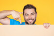 © Volodymyr - Man holds sign with copy space. Placard ready for copy space product. Sign to your copy space text. Man showing blank sign board on studio background, pointing finger. Empty copy space blank board.