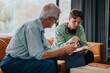 © qunica.com - An elderly man guides a young student in a quiet home environment. The scene captures learning, mentorship, and focus, emphasizing the importance of educational connections.