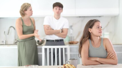 Wall Mural - Woman and young guy swear at girl. Mom and older brother scold young girl for unsuccessful studies at university. Complex intergenerational relationships