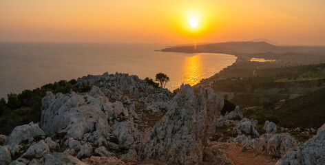 Wall Mural - sunrise over the island of zakhyntos from a vantage point on the rocks