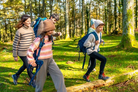Family trekking in a green alpine forest