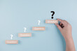 © Bussarin - Wooden cube block in question mark mean what on cement table background, column of wooden blocks with question sign mark. copy space,FAQ frequently asked questions, Answer, Information