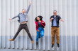 © Westend61 - Happy friends jumping together in front of wall