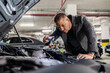 © Dusan Petkovic - A young elegant man is looking under car hood at garage and preparing for a long trip.