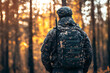 © Andrey - Soldier walking in forest at sunset wearing camouflage uniform and backpack