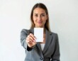 © Adeniadit - Businesswoman holding blank id card isolated on white background. Focus on the ID Card and blur behind it