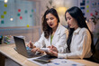 © Apichat - Two women are sitting at a desk, working on a project
