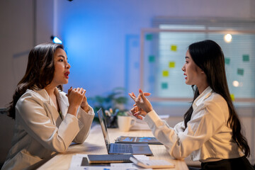 Wall Mural - Two women are talking in a room with a white wall and a blue background