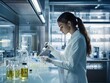 © shirophoto - A young women chemist is standing in font of counter table in a modern lab interior. She is mixing something in the glass tube.
