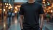 © horizon - Black t-shirt displayed on person in shopping mall setting, featuring lifestyle fashion photography with blurred retail environment and warm ambient lighting.