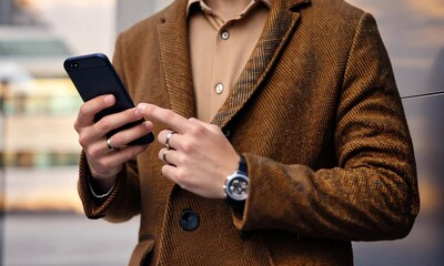 Fashionable guy with a phone, close-up. Modern man with a smartphone in his hands.