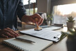 © ASSIASIA - Man stamping approval on financial, banking, or investment documents at his desk official paperwork. rubber stamp with contract law and business documentation for legal agreements financial