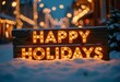 © Giuseppe Cammino - A beautifully illuminated wooden holiday sign that reads Happy Holidays adorned with warm lights, set against a serene, snowy street decorated with festive lights
