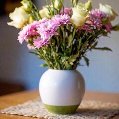 Wall Mural - Close-up shot of a bouquet placed in a vase, with one flower in sharp focus and the rest of the arrangement softly fading, capturing the harmony and balance of the floral display