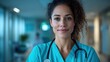 ©  Shomixer - A nurse wearing a teal uniform exudes confidence and warmth in a clinical hallway, representing reliability and compassion within a professional healthcare context.