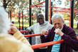 © Marko Geber - Senior men socializing and relaxing at outdoor park fitness area