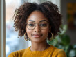 © JSC_Digital - Confident Stylish African American Woman with Curly Hair Round Glasses Gold Hoop Earrings Mustard Yellow Sweater in Cozy Natural Light Setting