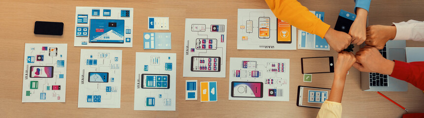 Wall Mural - top view banner of startup company ui or ux developer joining hand over user interface prototype for