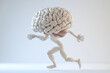 © wernerimages - A conceptual art piece depicting a muscular human-like form with a brain for a head, dynamically posed in a running position against a neutral background.