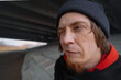 © Алексей Филатов - A man with a playful expression under a concrete bridge, showcasing an intriguing moment on a cool afternoon in an urban landscape